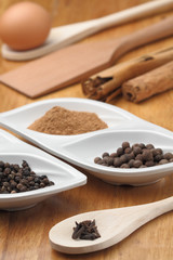 spices in spoons on wooden background