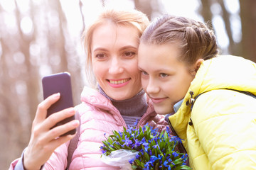 Girl with mom take a selfie in nature.