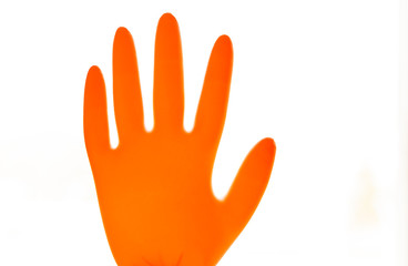 Inflated orange rubber glove isolated on white background