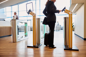 Elegant lady passing electronic turnstile at airport