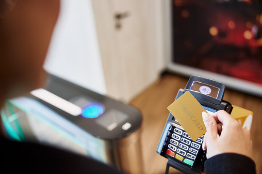 Young lady using gold card for contactless payment