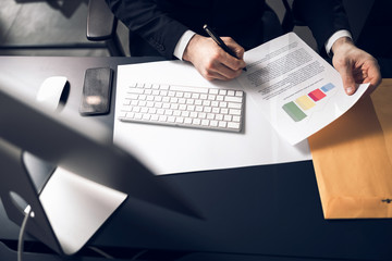 Cropped photo of office worker signing documents indoors