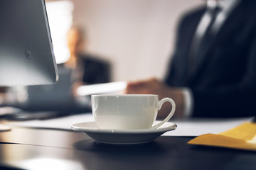 Cropped photo of cup with warm beverage on table