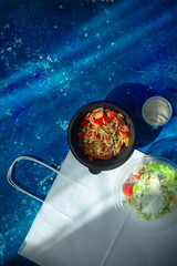 Take out flat lay with chicken udon and Ceasar salad in plastic packaging