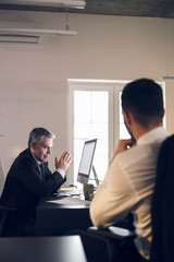 Mature boss sitting at his workplace indoors