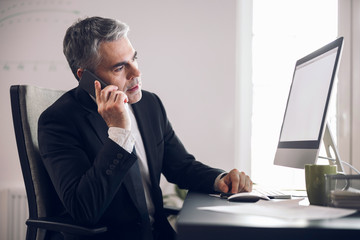 Mature businessman in suit working in office