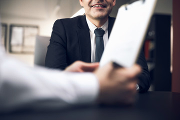 Cropped photo of boss smiling at the meeting