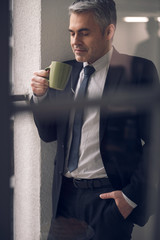 Caucasian attractive boss enjoying his beverage in balcony