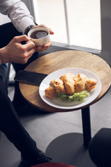 Cropped photo of man using his cellphone in cafe