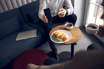 Young businessman using mobile phone in cozy apartment