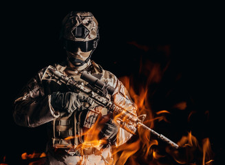 Desert soldier in uniform standing in fire.