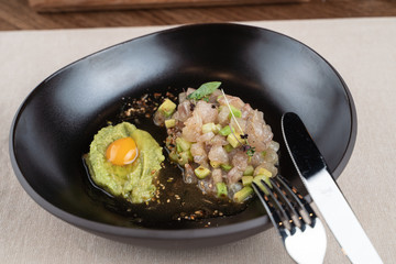 Scallop tartare with raw quail egg and avocado puree