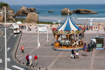 Carousel on the beach at Biarritz with ocean behind