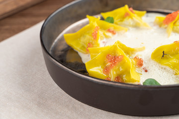 Italian bright yellow ravioli with crab meat and red caviar