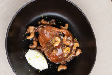 Moist rum cake with cashew nuts and caramel as a delicatessen dessert in a restaurant