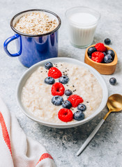Breakfast oatmeal porridge with fresh berries and almond milk. Healthy vegan food concept. Top view. Copy space. Flat lay