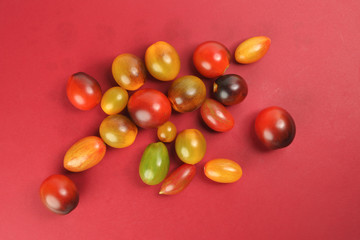 Fresh ripe mixed tomato verity assorted color on red background
