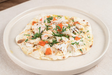 Wheat crunchy tortilla with crab meat, greens and red caviar in a seafood restaurant