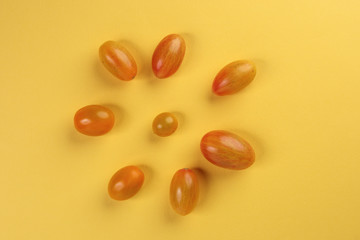 Fresh ripe mixed tomato verity assorted color on yellow background