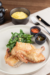 Whole chicken baked and sliced in halves with herbs and sauces in a restaurant