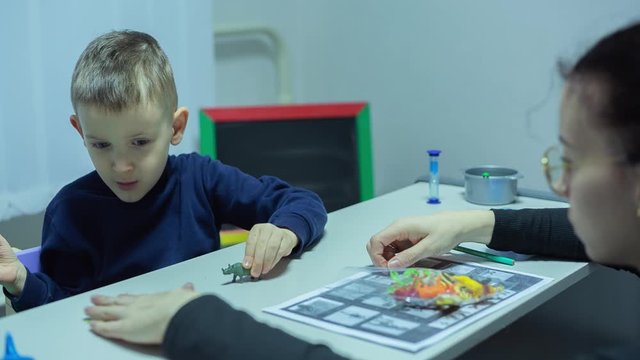 Little Boy with autism syndrome Learning homework And Playing games at Home on quarantine
