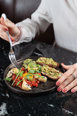 Eating raw meat tartare with fork, woman hands is in the shot