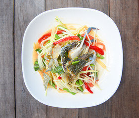 Papaya salad with blue crab / Thai food raw crab spicy salad seafood and vegetable on wooden table