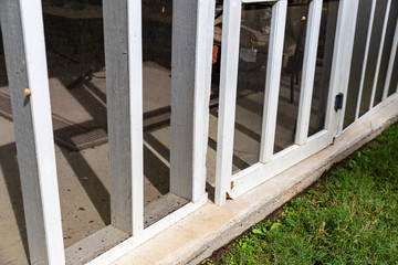 Wooden screen door on back porch with rotten wood
