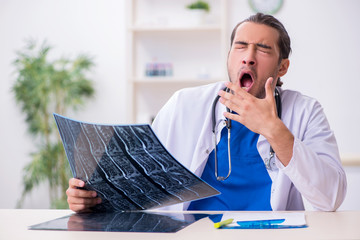 Young male doctor being tired after night shift