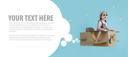 Asian little child girl playing with cardboard toy airplane handicraft over the clouds on blue sky long banner with copy space for your text, Creative with family and dreaming of flying concept