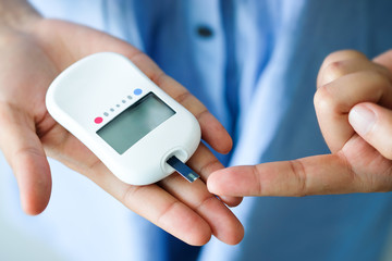 hand of people check diabetes and high blood glucose monitor with digital pressure gauge. Healthcare and Medical concept