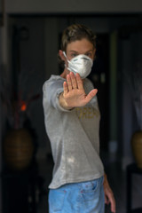 woman wearing a face mask holding up her hand, social distancing concept