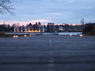 Widok na budynki z perspektywy pomostu nad jeziorem