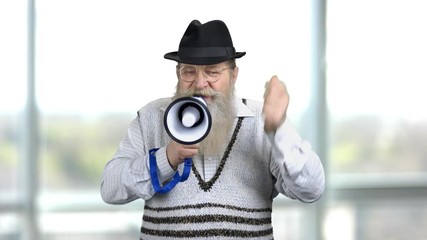 Old bearded man making encourage speech in megaphone. Retired man in casual close yelling and strongly speaking indoors. Revolutionary grandpa. - Powered by Adobe