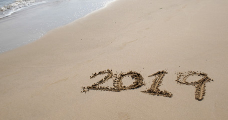 Number 2019 on sandy beach for new year concept