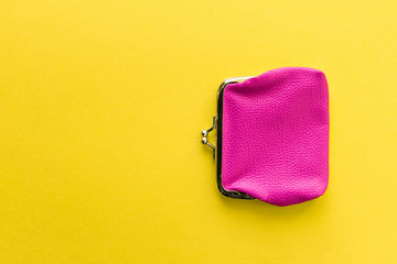 Fashionable pink wallet on a yellow background. Close up.