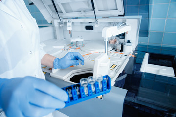 Blood test scientist working with auto robot laboratory medical equipment