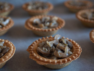 Chanterelle mushrooms tartlets on white background.