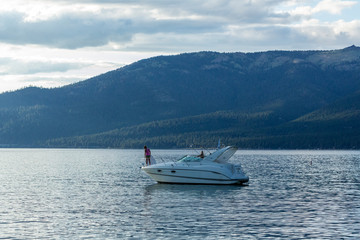 Boats anchored near a beach at sunset in lake tahoe
