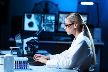 Female scientist working in modern lab. Doctor making microbiology research. Laboratory tools:...