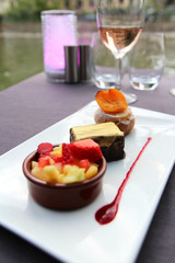 Focus on the intense chocolate ingot and blurred for cream pastry with apricot medallion and mixed fresh seasonal fruit