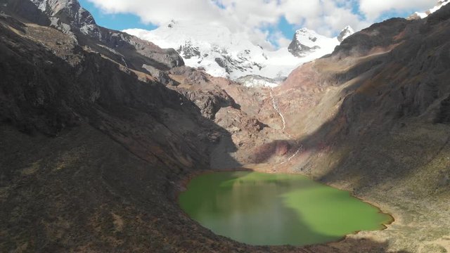 Shallap, the green lake in the peruvian andes, river and lake product of the defrosting glaciers, pan shot, aerial shot, amazing view.