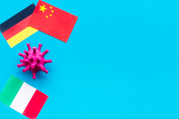 Concept of Corona virus Covid-19 with german, italian and chinease flags on blue background top-down