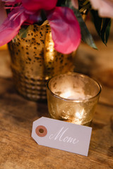A beautfifully calligraphed place card for Mom at a celebration table