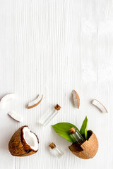 Cosmetic coconut oil for skin care on white wooden background top-down frame copy space