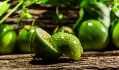 Passion fruit (Passiflora edulis) fruits and pulp on wooden background and green leaves
