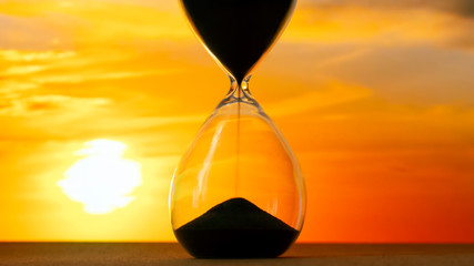 Hourglass on the background of a sunset. The value of time in life. An eternity.