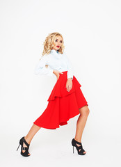 Blond fashion model with luxury hair and red skirt in studio over white background