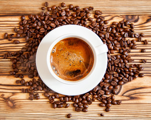 White cup of coffee stands on coffee beans