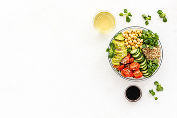 Healthy salad bowl with quinoa, avocado and chickpeas on white background top-down copy space